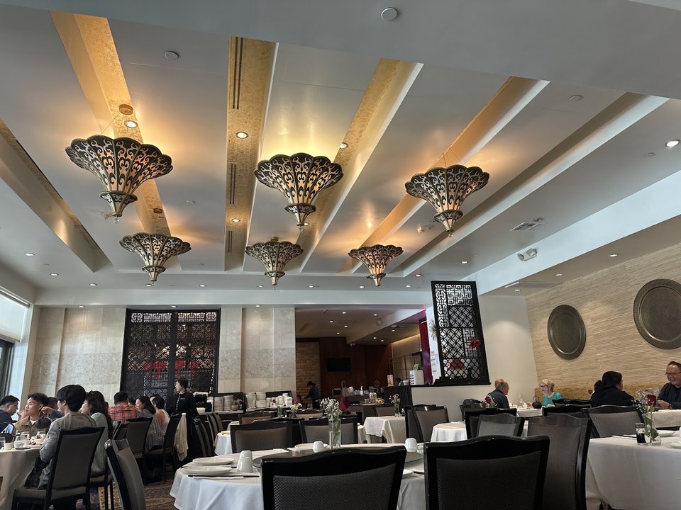 Spacious dining room with round tables and chairs.