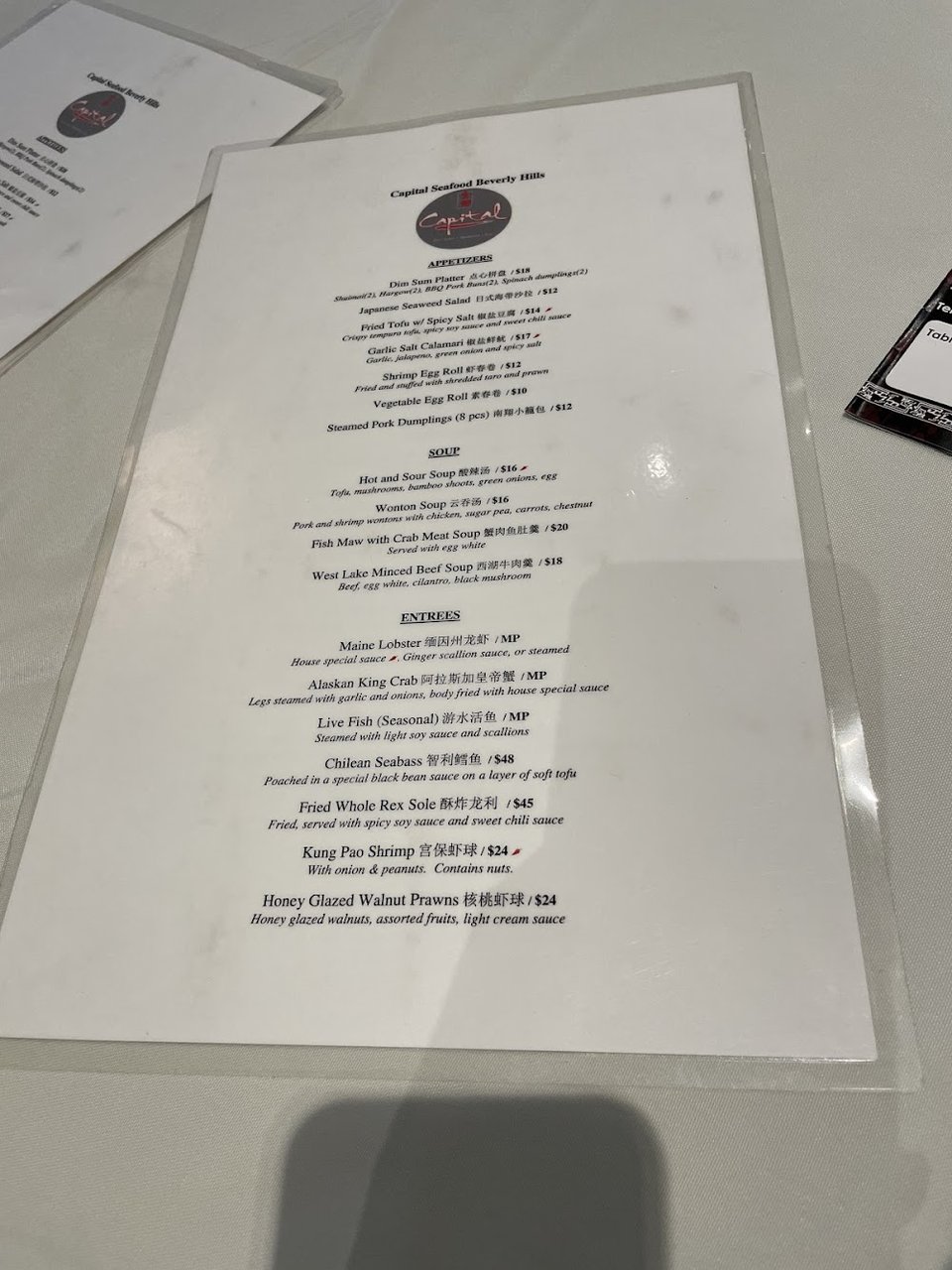 Printed menu highlighting rice noodles and live seafood.