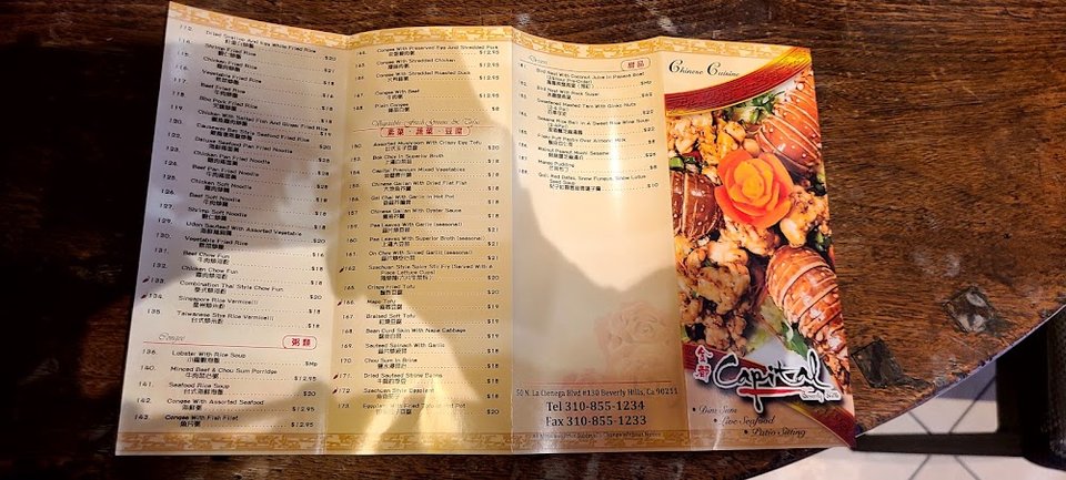 Printed menu highlighting rice noodles and live seafood.